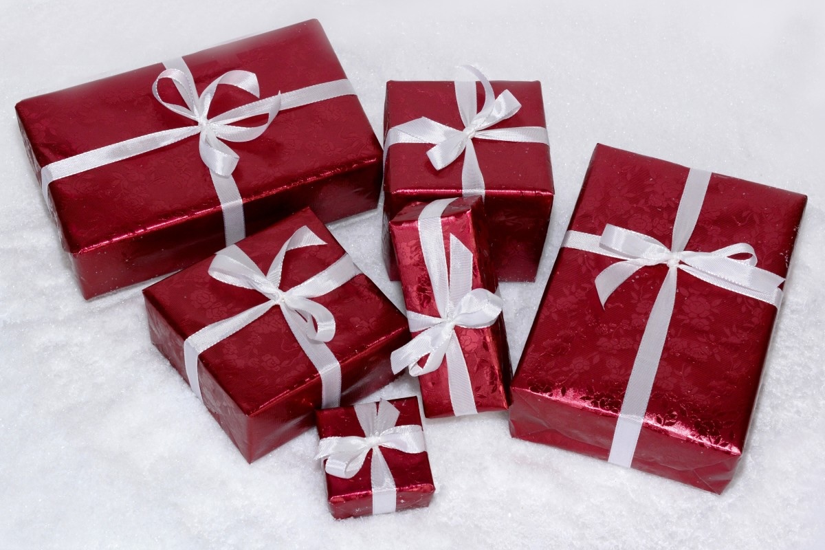 This image shows a Christmas postcard depicting red gift boxes decorated with white ribbon.